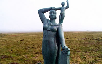 A woman holds her child on her broad shoulders, so both can see further.